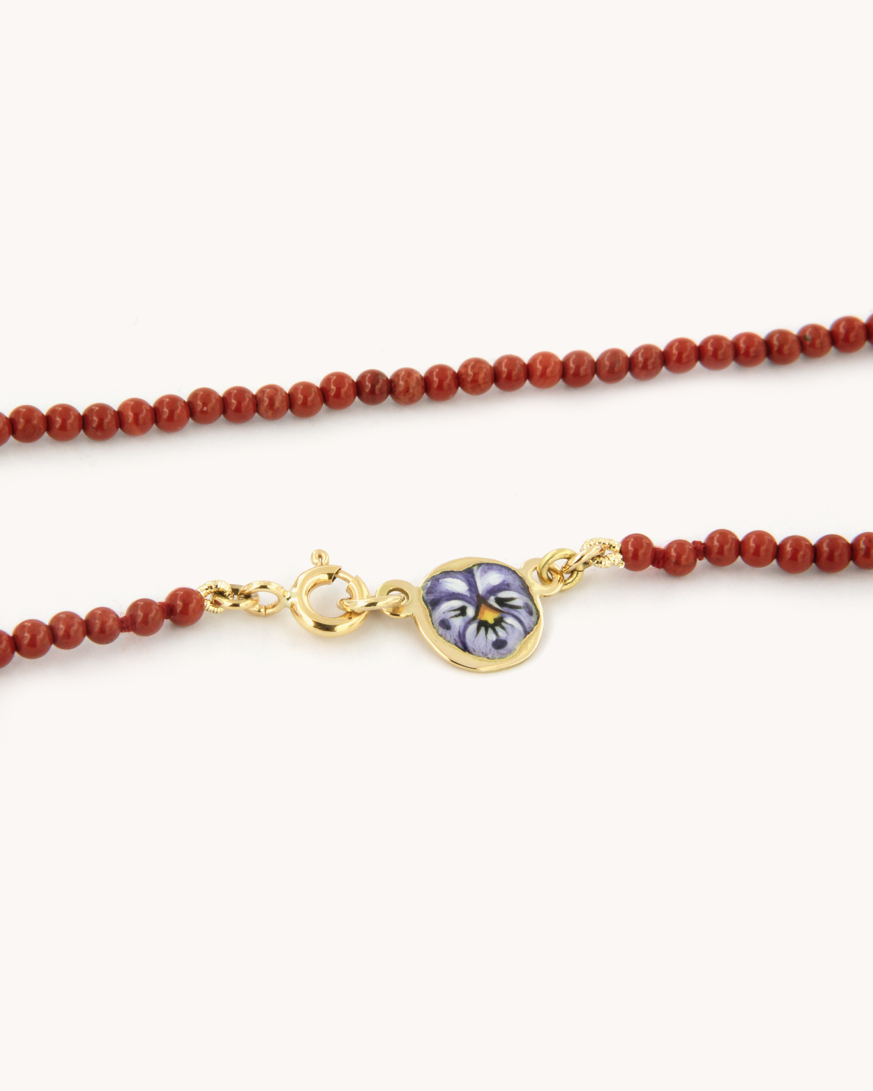 Collana infilata con perle di diaspro rosso e piastrina in oro giallo 18 carati decorata con fiore di pansè in smalto a fuoco dipinto a mano