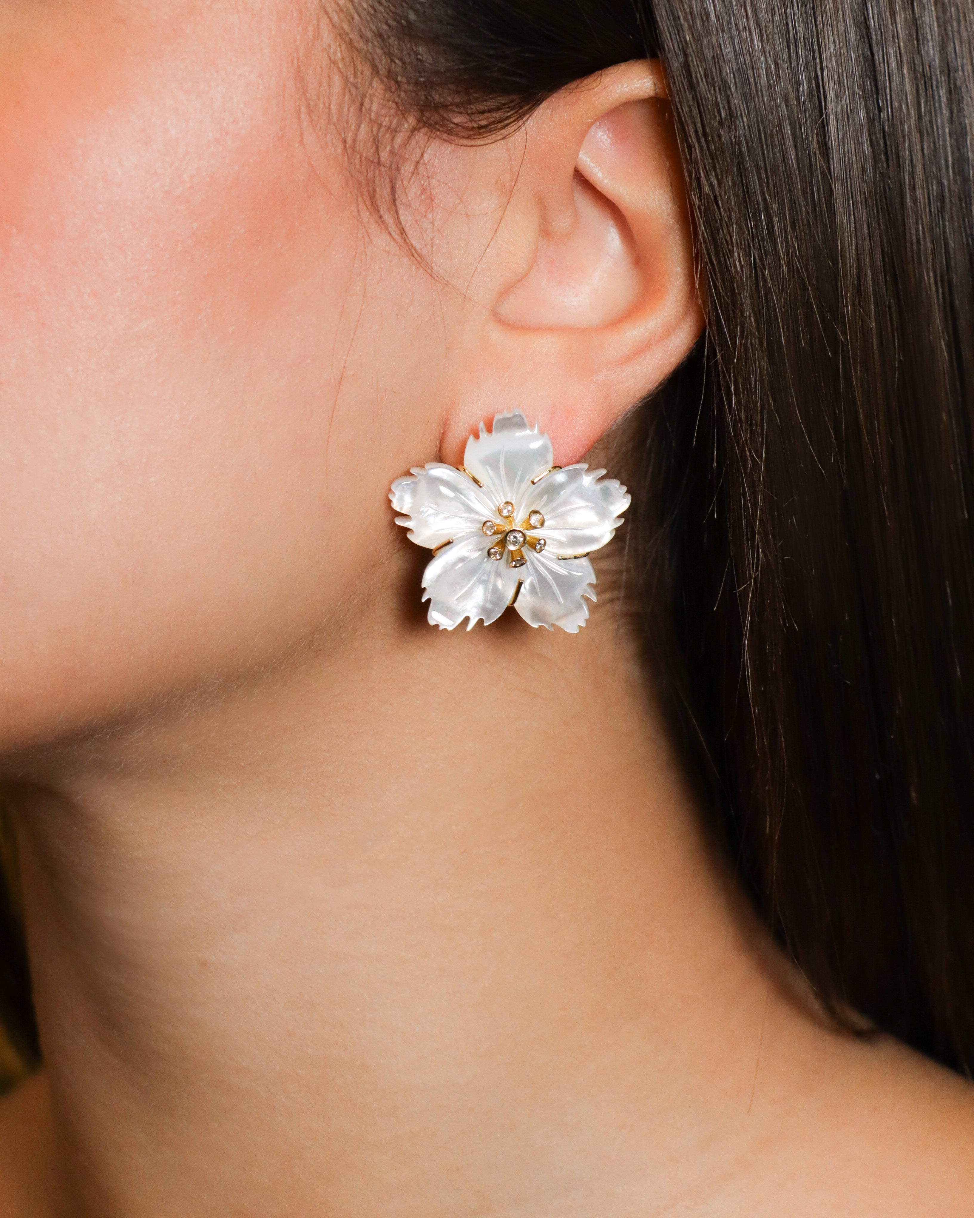 Orecchini a lobo con fiori in madreperla intagliata, impreziositi da diamanti al centro, in oro giallo 18K.