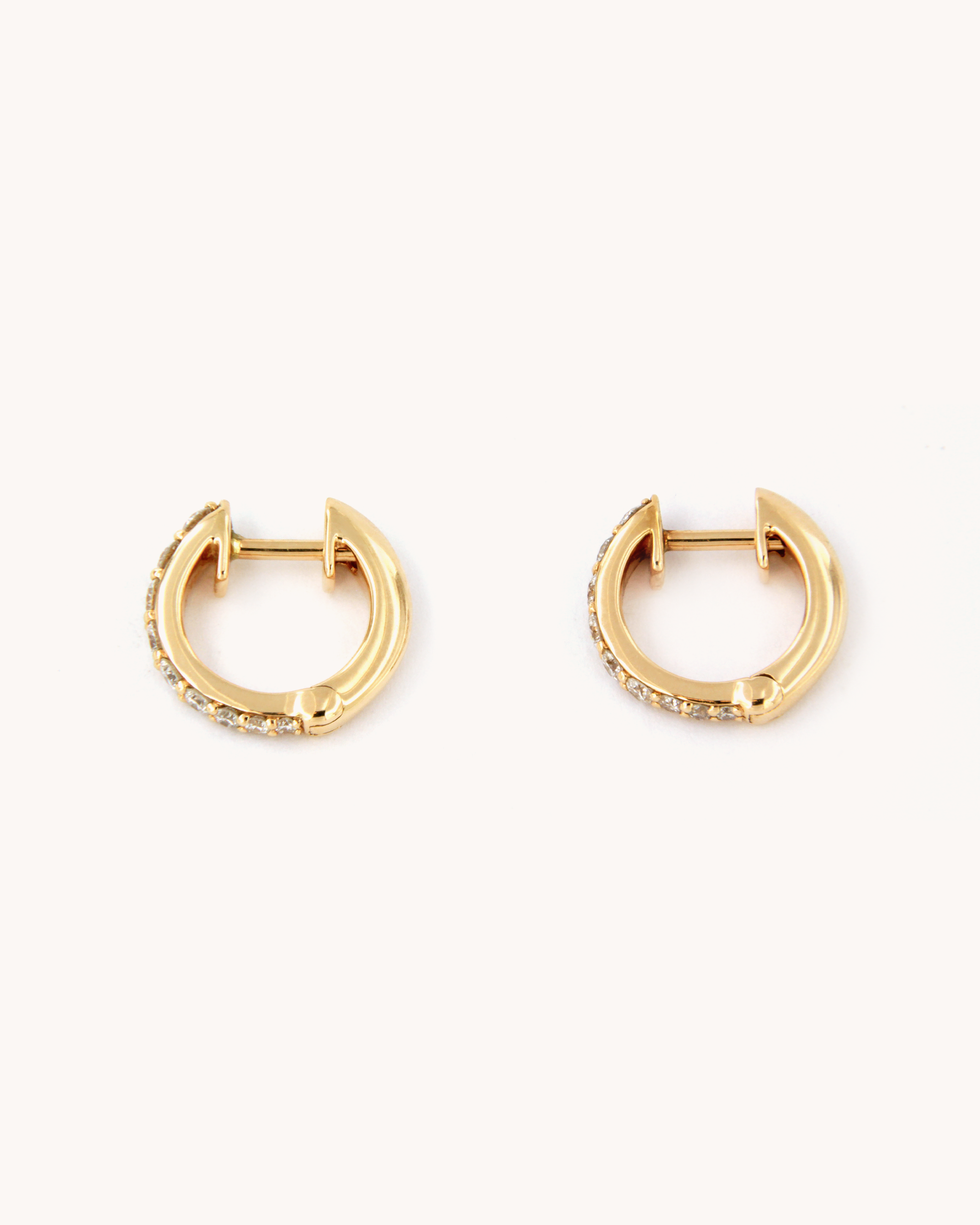 Orecchini a cerchio in oro rosa 18 carati con diamanti incastonati lungo il profilo.
