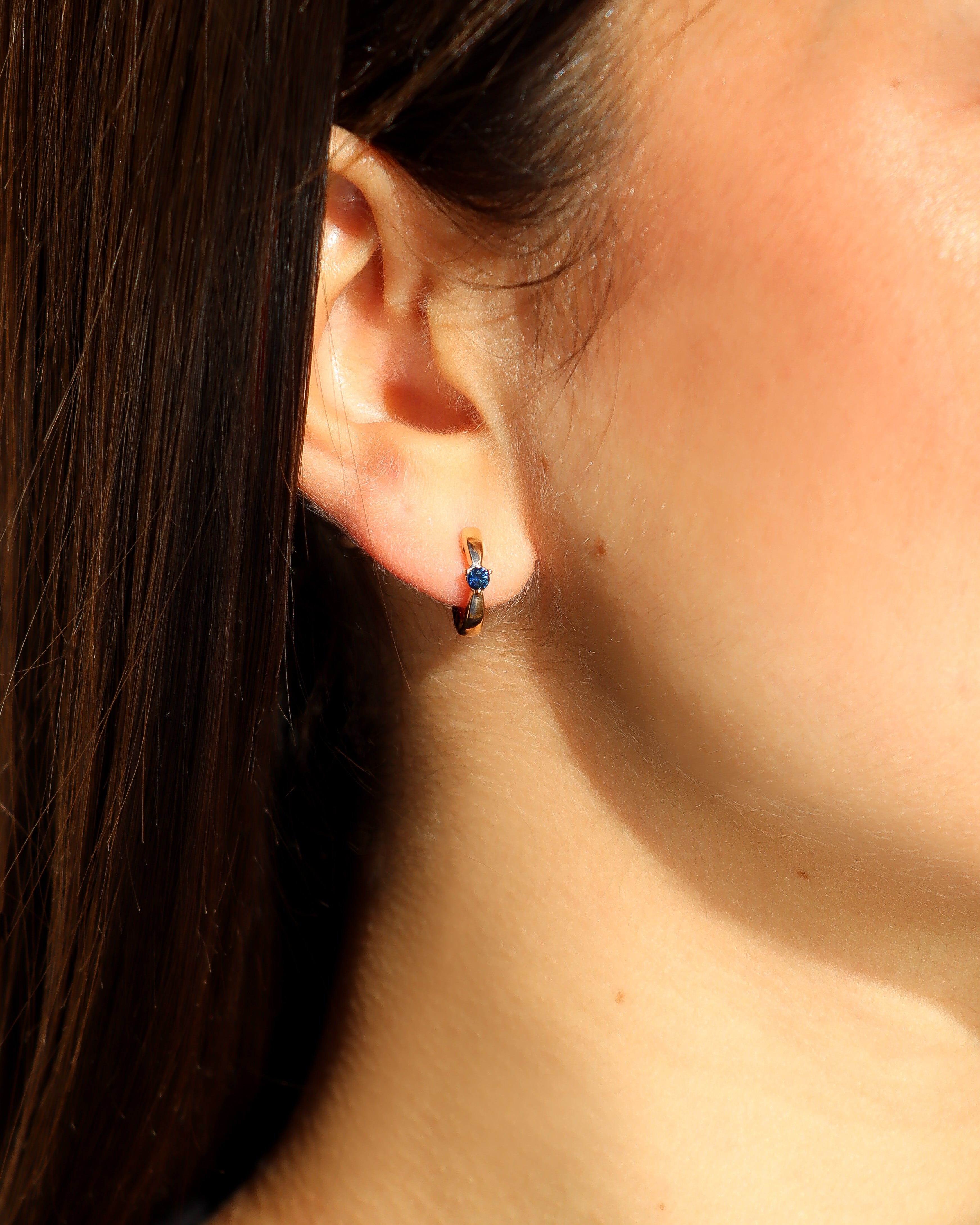 Orecchini a cerchio in oro rosa 18 carati con zaffiro centrale.